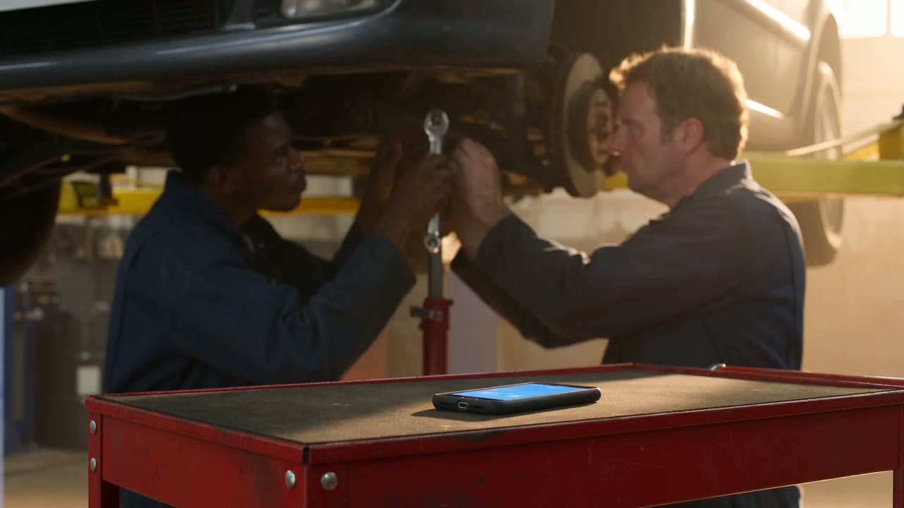 Technicians working in a South Florida service bay while a phone rings